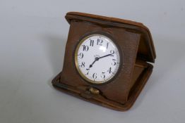 An antique Brevete eight day travel clock in leather case, 11 x 11cm