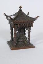 A bronze model of a shrine with pagoda roof and three Buddhas, 15cm high