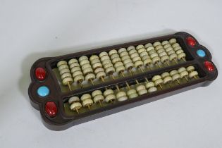 A Chinese hardwood abacus with inset decoration and jade bead counters, 42 x 15cm