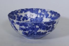 A C19th Oriental blue and white bowl with lobed body and dragon decoration 20cm diameter