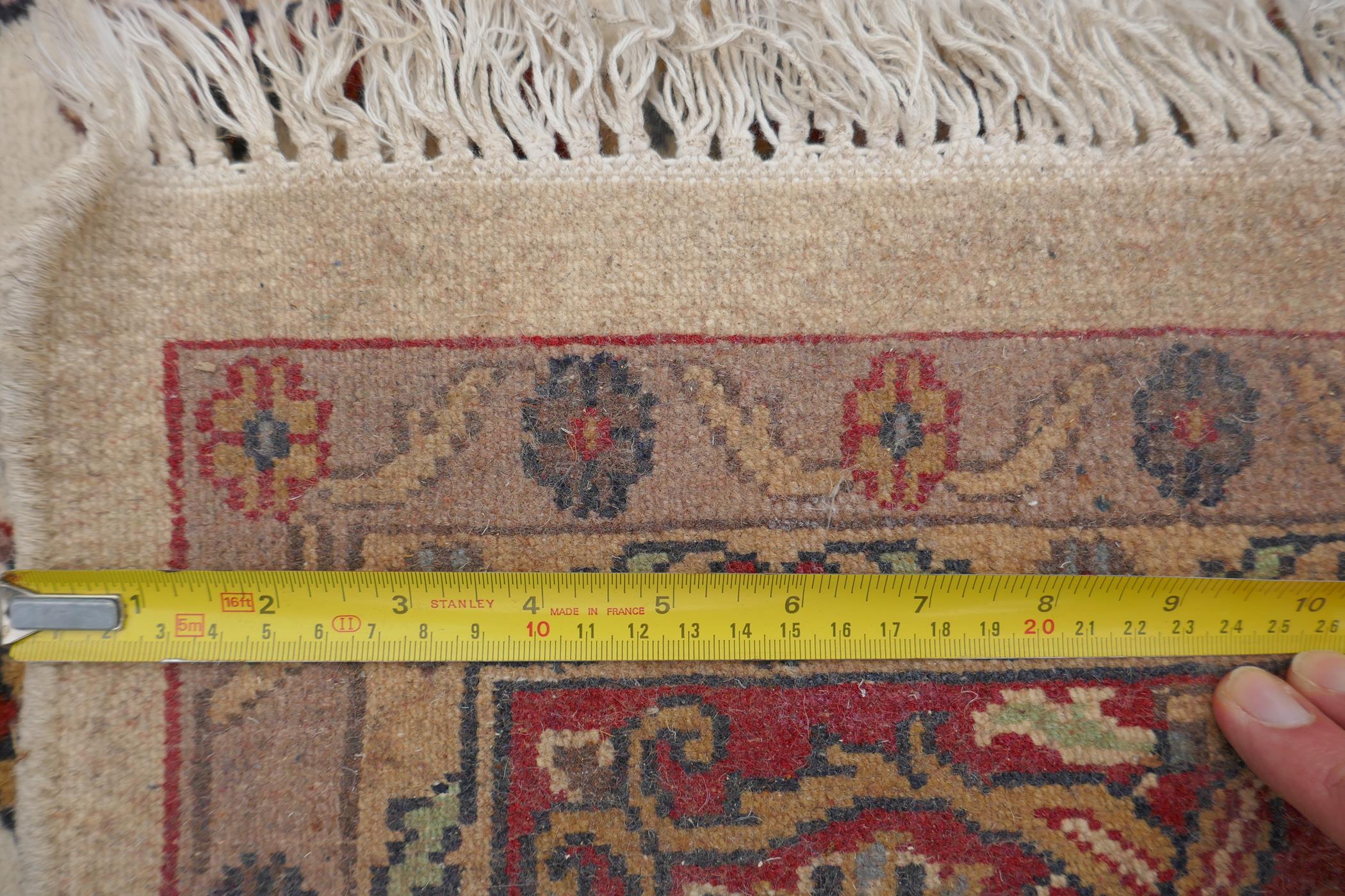 A Persian ivory ground wool Tabriz carpet with a floral medallion and red borders, 180 x 284cm - Image 6 of 6