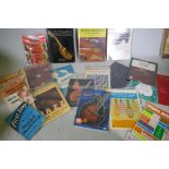 A collection of books, musical instruments, folk and African, guitars and instruction manuals