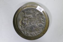 A Sasanian style cast bronze dish with raised decoration depicting a lion hunt, 20cm diameter