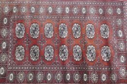 A Bokhara hand woven deep red ground rug with traditional pattern, 130 x 80cm