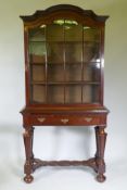 A C19th Dutch mahogany dome topped glazed display cabinet, with single door on a base with one