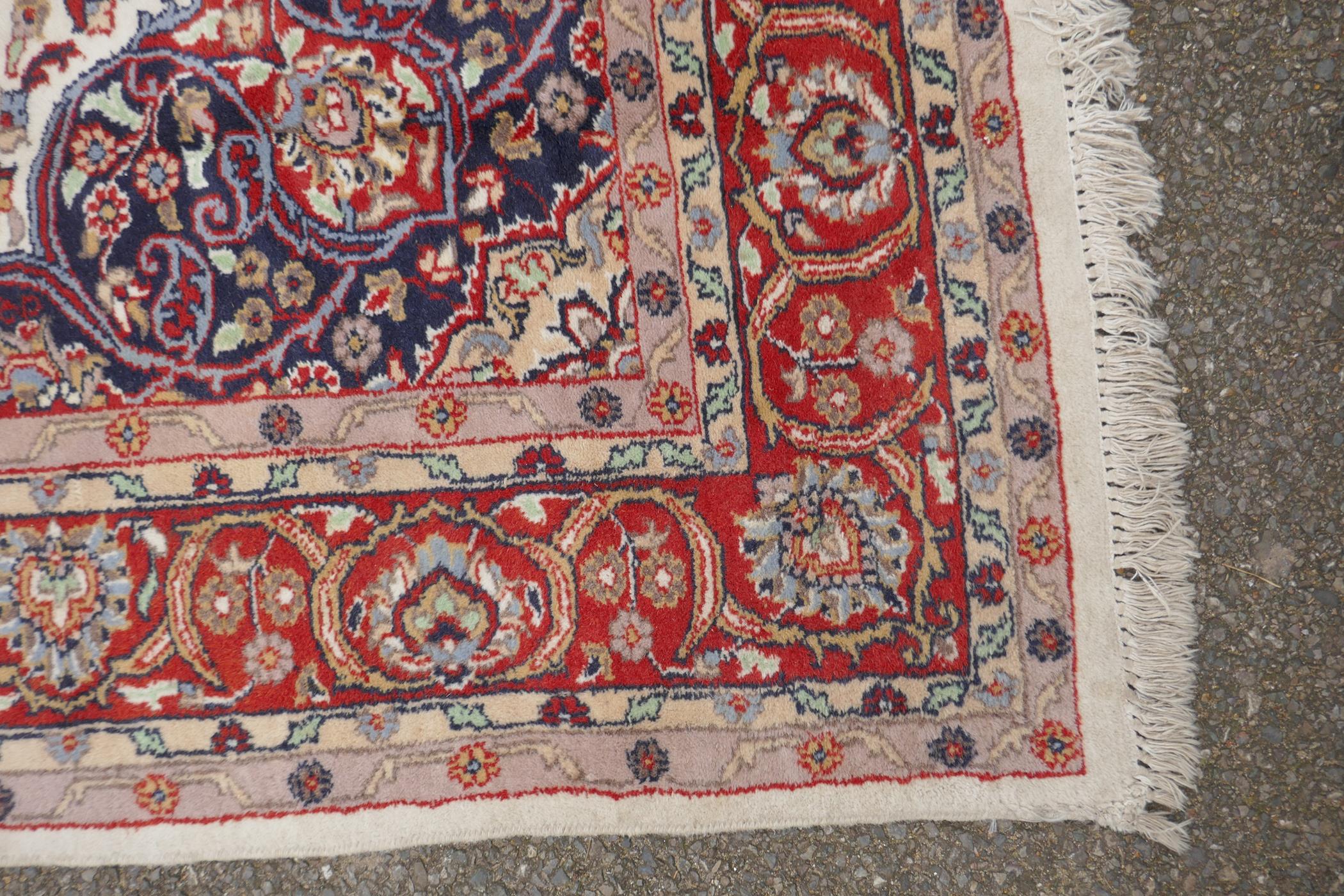 A Persian ivory ground wool Tabriz carpet with a floral medallion and red borders, 180 x 284cm - Image 4 of 6