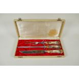 A cased carving set by Anton Wingen Jr of Solingen, Germany, with carved antler handles decorated