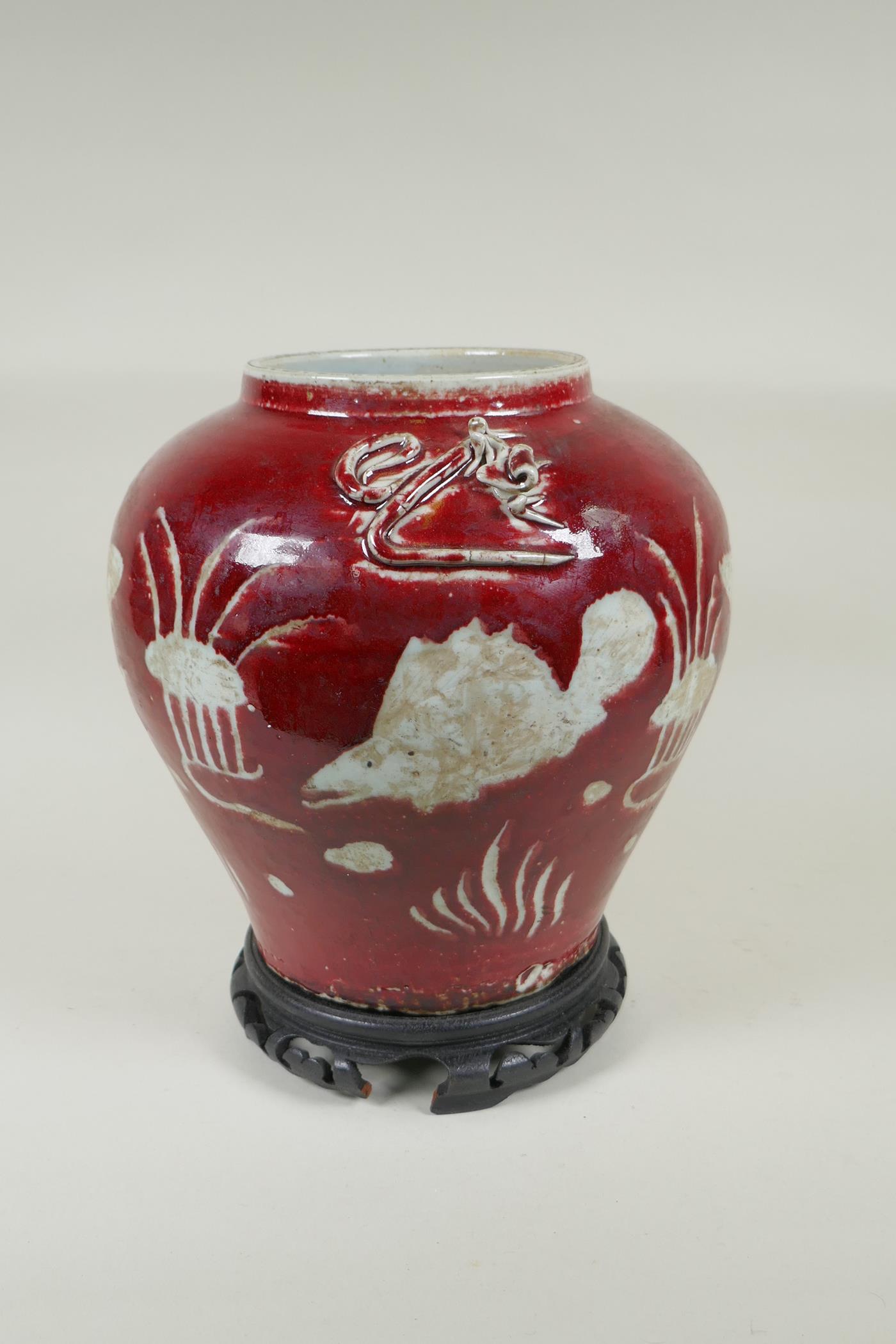 A Chinese red and white porcelain baluster vase, decorated with carp in a lotus pond, on a carved - Image 2 of 5