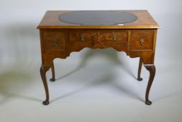 A Georgian style walnut kneehole desk, with leather inset top over three drawers and shaped apron,