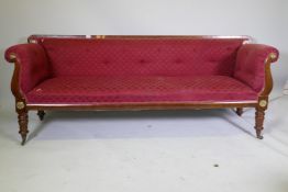 A C19th Continental mahogany settee, with scrolled arms and brass mounts, raised on turned supports,
