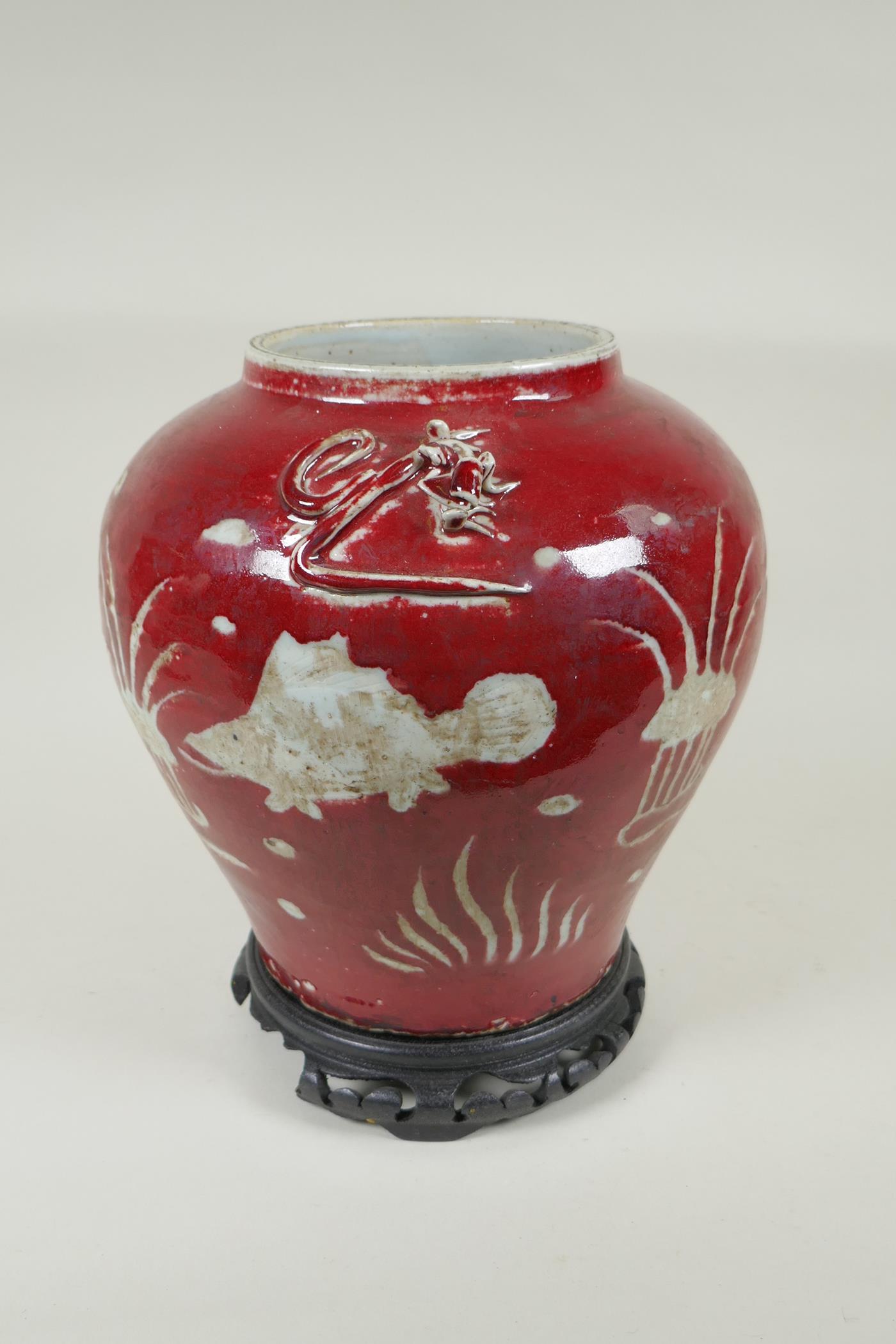 A Chinese red and white porcelain baluster vase, decorated with carp in a lotus pond, on a carved - Image 4 of 5