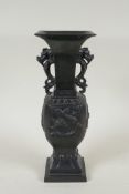A Japanese bronze vase with twin dragon handles and raised dragon decoration to the side, indistinct