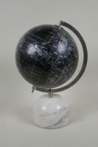 A black terrestrial globe on a reconstituted marble base, produced in India, 33cm high