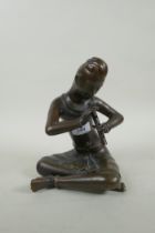 A Thai filled bronze figure of a musician playing the flute, 23cm high