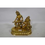 An Oriental gilt bronze figure group, Buddha accompanied by a female musician, 29cm high