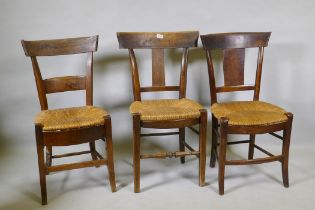 A harlequin set of three antique provincial rush seated dining chairs