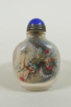 A Chinese reverse decorated glass snuff bottle on a ring, decorated with a green dragon and a red