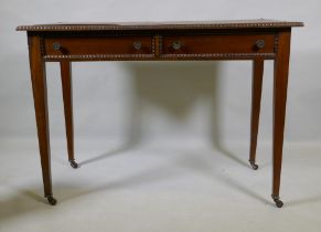 A C19th mahogany writing table, with inset faux leather top, carved bead edge over two drawers,