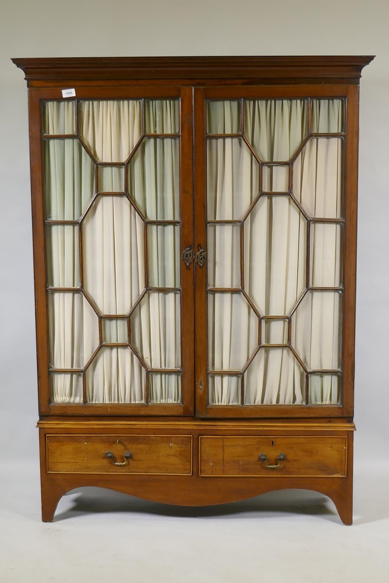 A Victorian mahogany bookcase with two astragal glazed doors over two drawers, raised on shaped