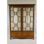 A Victorian mahogany bookcase with two astragal glazed doors over two drawers, raised on shaped