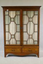 A Victorian mahogany bookcase with two astragal glazed doors over two drawers, raised on shaped