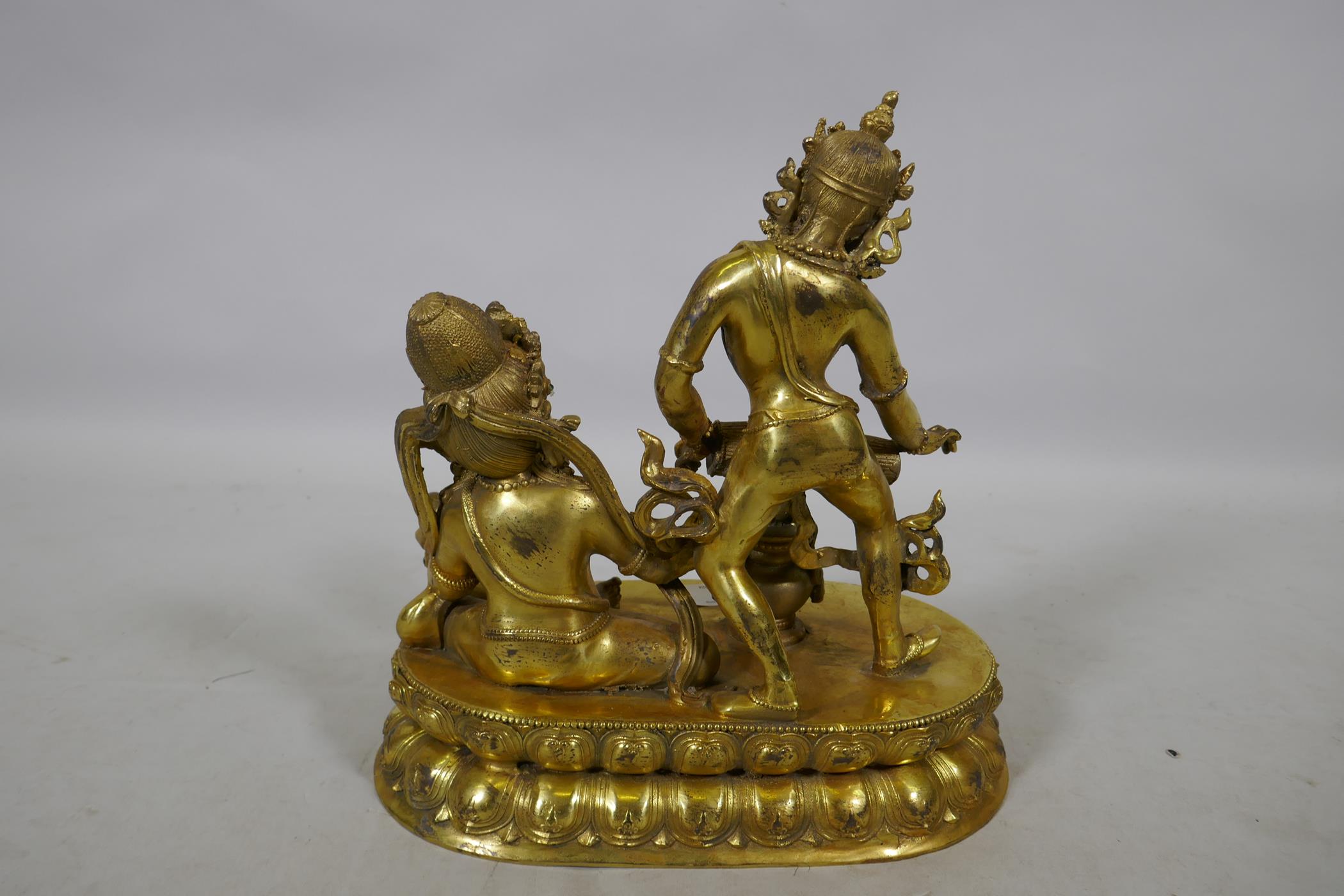 An Oriental gilt bronze figure group, Buddha accompanied by a female musician, 29cm high - Image 3 of 3
