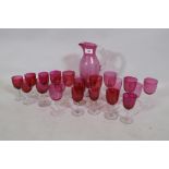 A quantity of matched cranberry coloured drinking glasses and a carafe, 27cm high