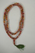 A string of multicolour hardstone/jade mala beads with the remnants of gilt lustre, 122cm long