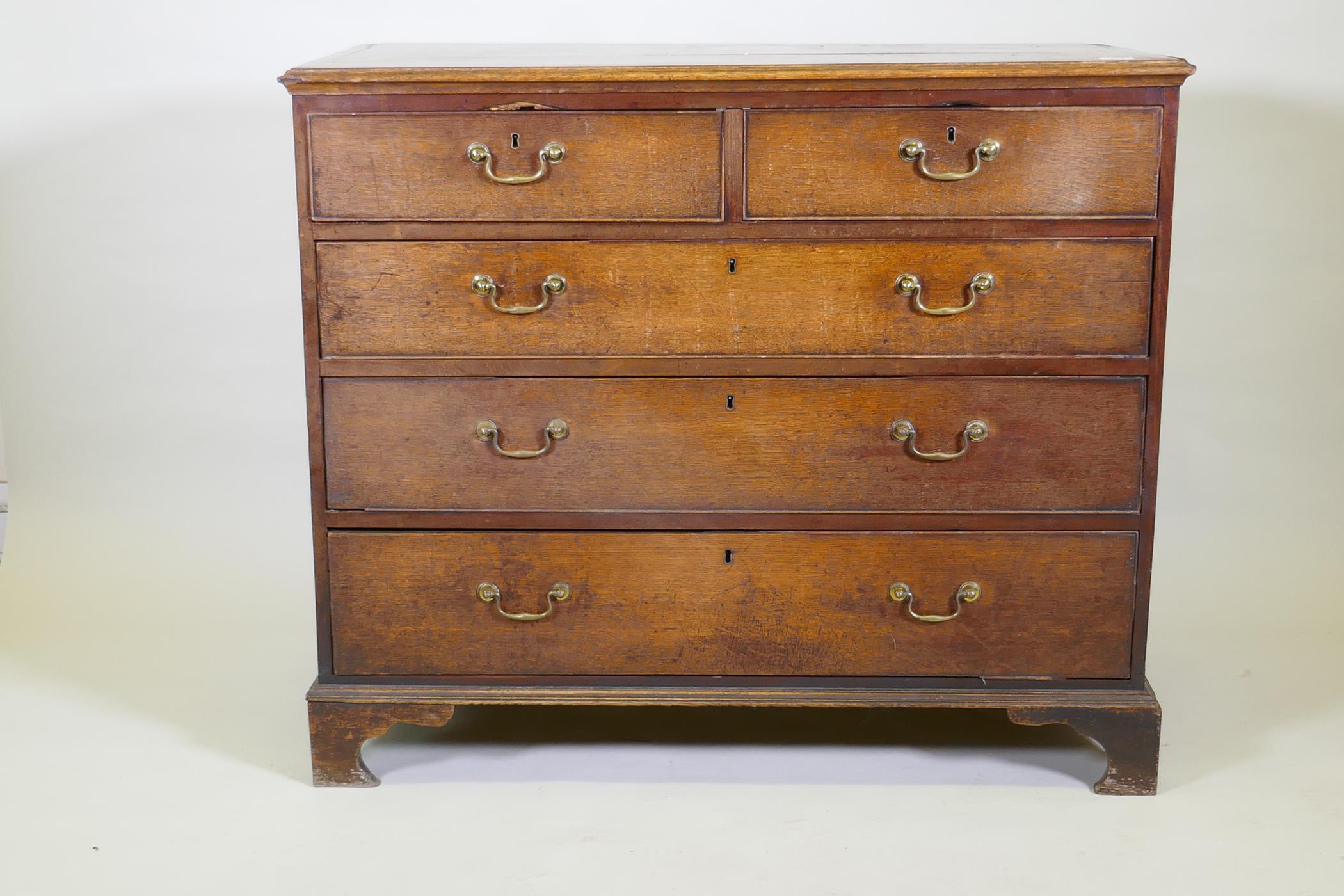 A Georgian oak chest of two over three drawers, mahogany banded top, cockbeaded drawers with