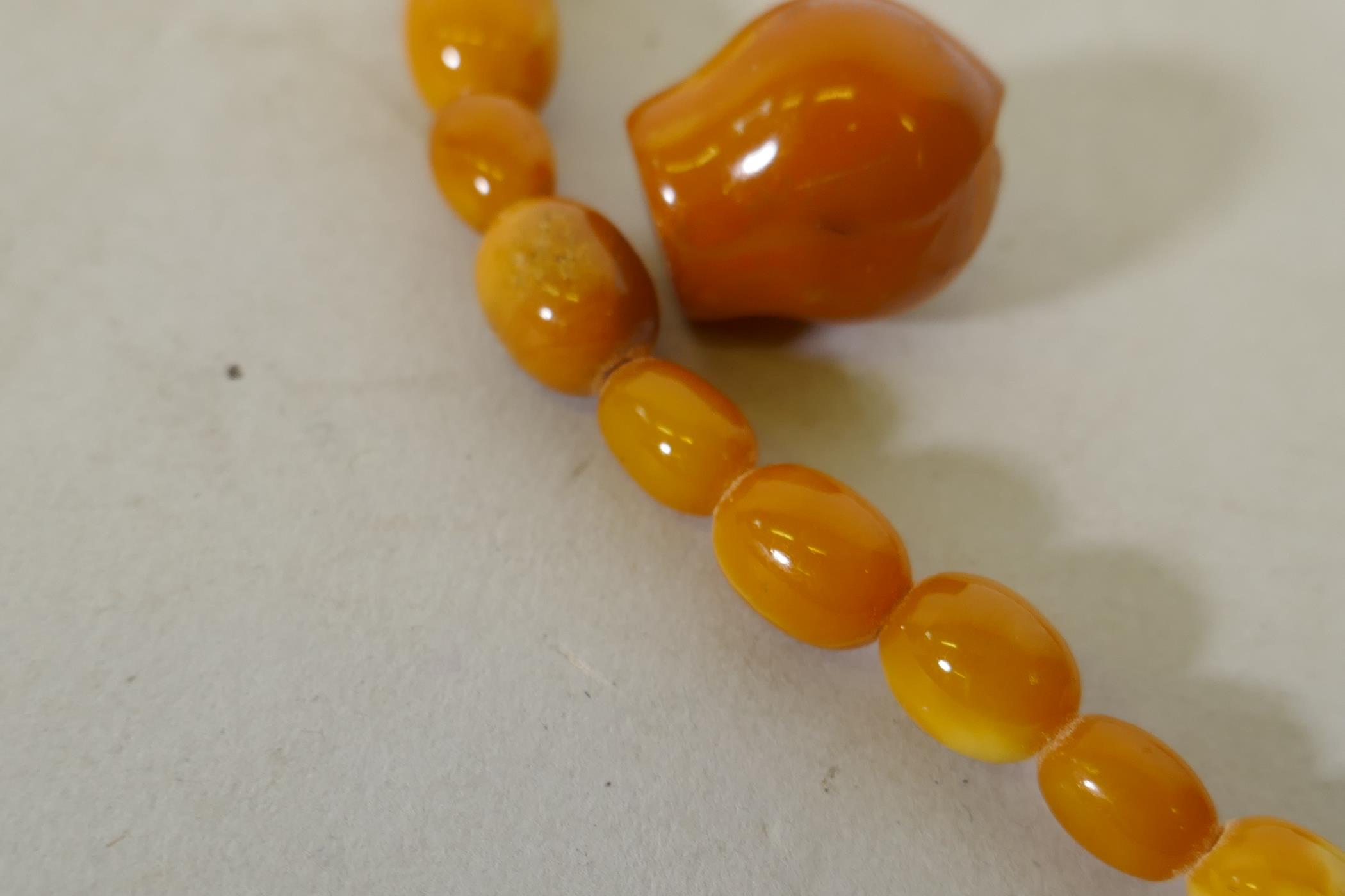 A vintage amber bead necklace and two loose beads, 24g, 36cm long - Image 2 of 3
