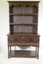 A late C19th oak potboard dresser with enclosed rack and pierced frieze, the base with two drawers