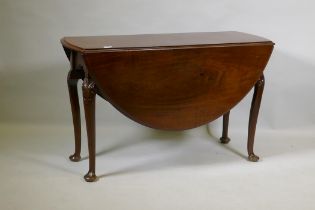 A Georgian mahogany drop leaf table, with oval top and shaped end frieze, raised on cabriole