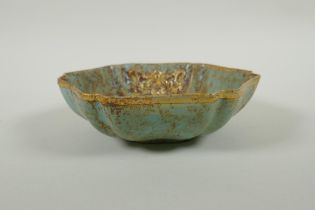 A Chinese celadon ground porcelain dish with a lobed gilt metal rim and applied gilt metal bird