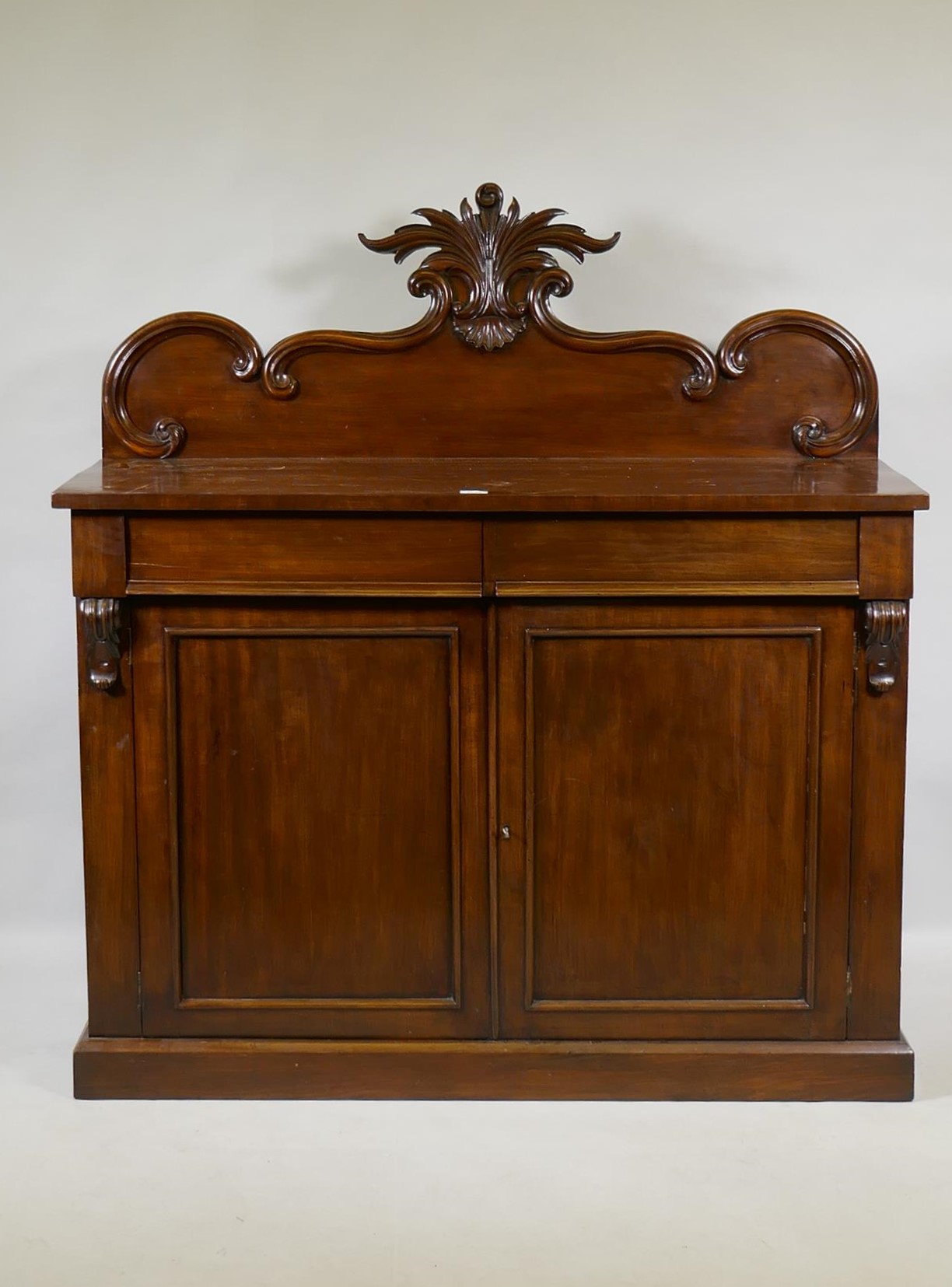 A Victorian mahogany chiffonier, the back with carved crest, the base with two frieze drawers over