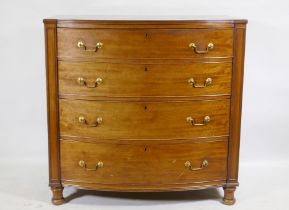 A C19th mahogany bow front chest of four long drawers, flanked by moulded panels and raised on