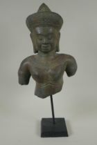 A Cambodian bronze bust of a female deity, on a display stand, 44cm high
