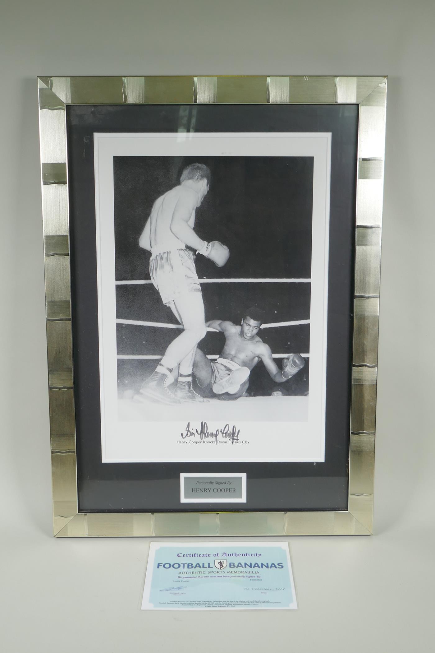 A framed signed photographic print of Henry Cooper knocking down Cassius Clay (Mohammed Ali) with