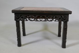 A Chinese carved and pierced hardwood table with an inset rouge marble top and bamboo shoot