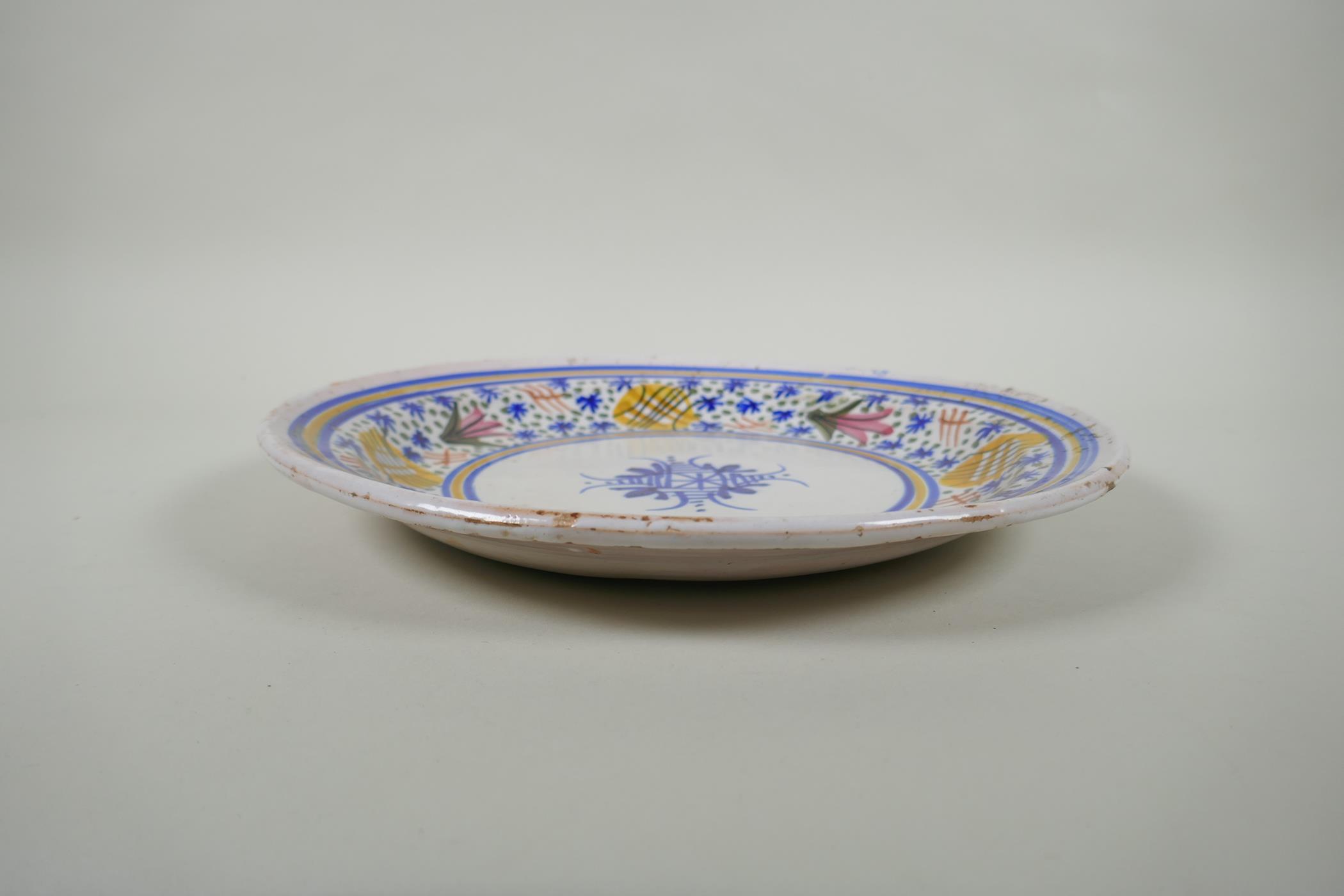 An antique Delft plate decorated with a floral design, 32cm diameter - Image 2 of 3