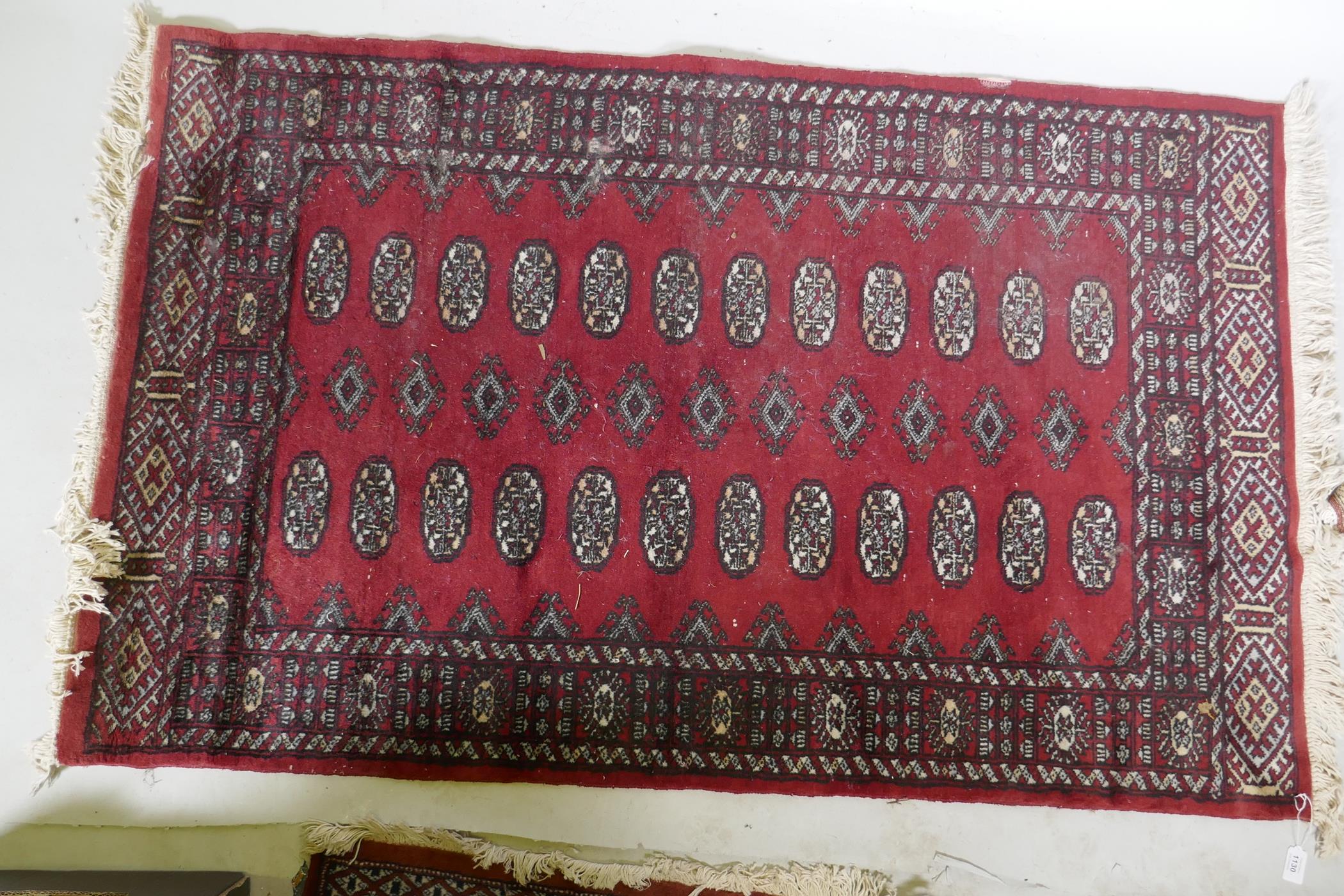 A Bokhara hand woven wool rug, red ground with traditional pattern, 7 x 157cm