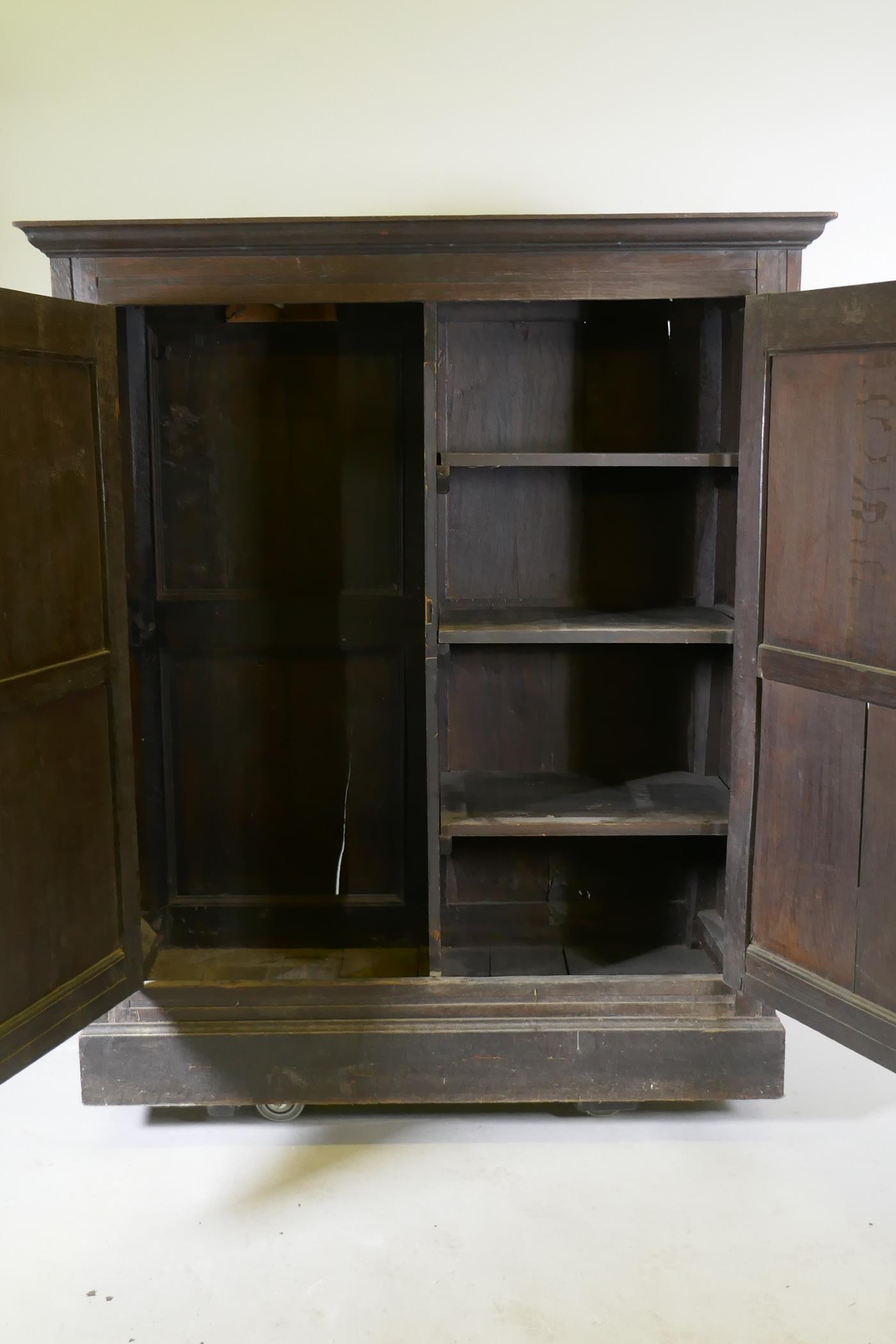 An early C18th two door cupboard with fielded panel doors and panelled sides, raised on a plinth - Image 5 of 5