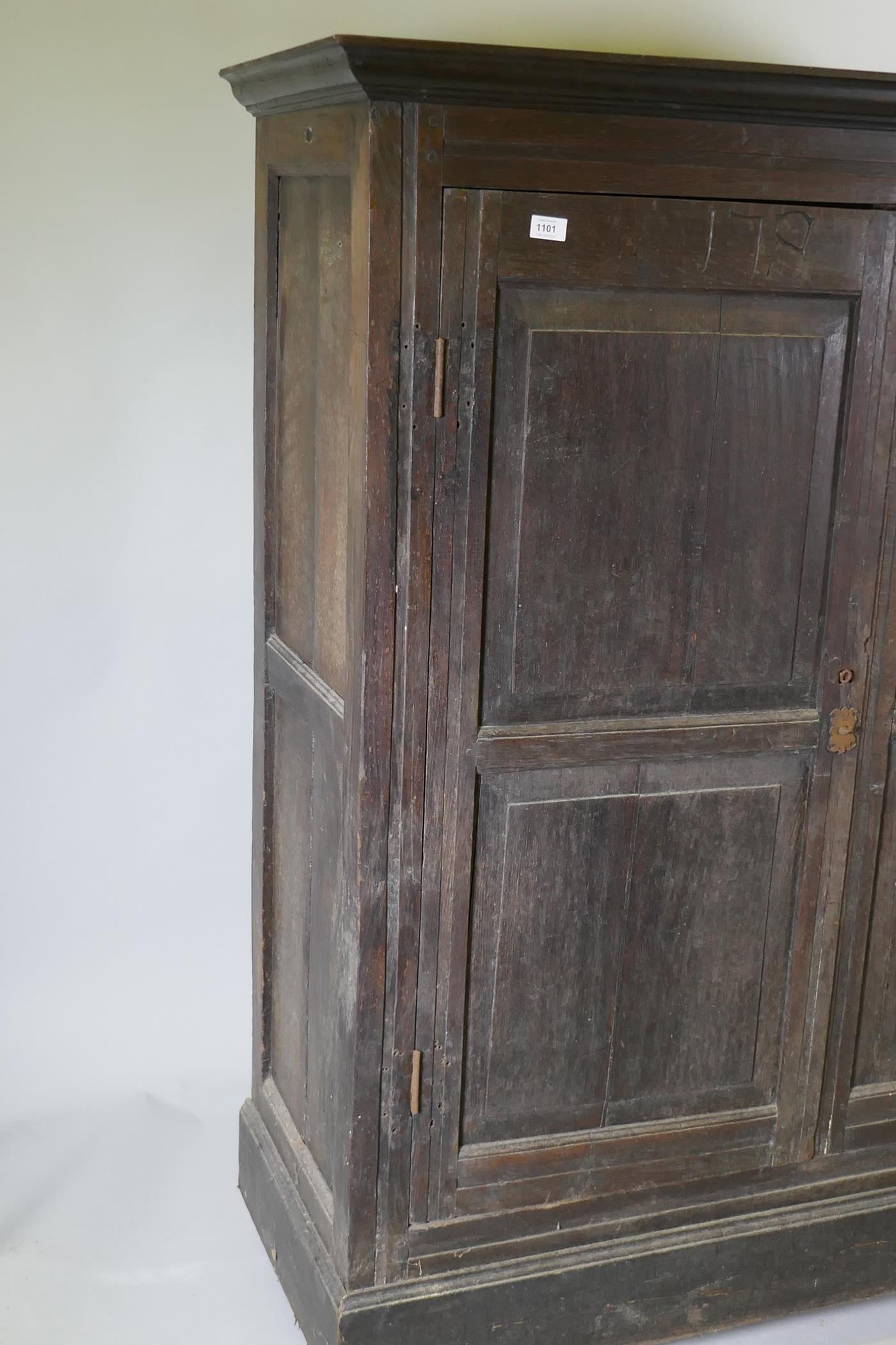 An early C18th two door cupboard with fielded panel doors and panelled sides, raised on a plinth - Image 2 of 5