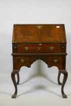 A Georgian style walnut kneehole bureau, the fall front with fitted interior over a single drawer