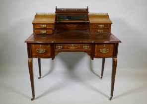 A Victorian inlaid mahogany inverted breakfront bonheure de jour, with pierced brass gallery top and
