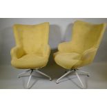 A pair of reclining swivel armchairs on spider legs