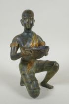 An antique oriental filled bronze figure of a kneeling woman carrying a bowl, 24cm high