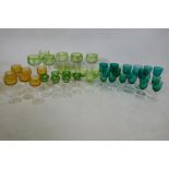 A quantity of matched green and yellow cut wine glasses, and green drinking glasses