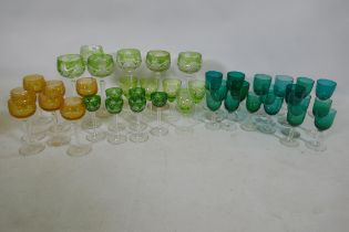 A quantity of matched green and yellow cut wine glasses, and green drinking glasses