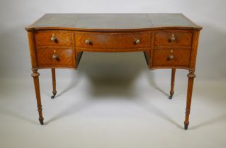 A Victorian satinwood serpentine front five drawer kneehole dressing table, with inset leather