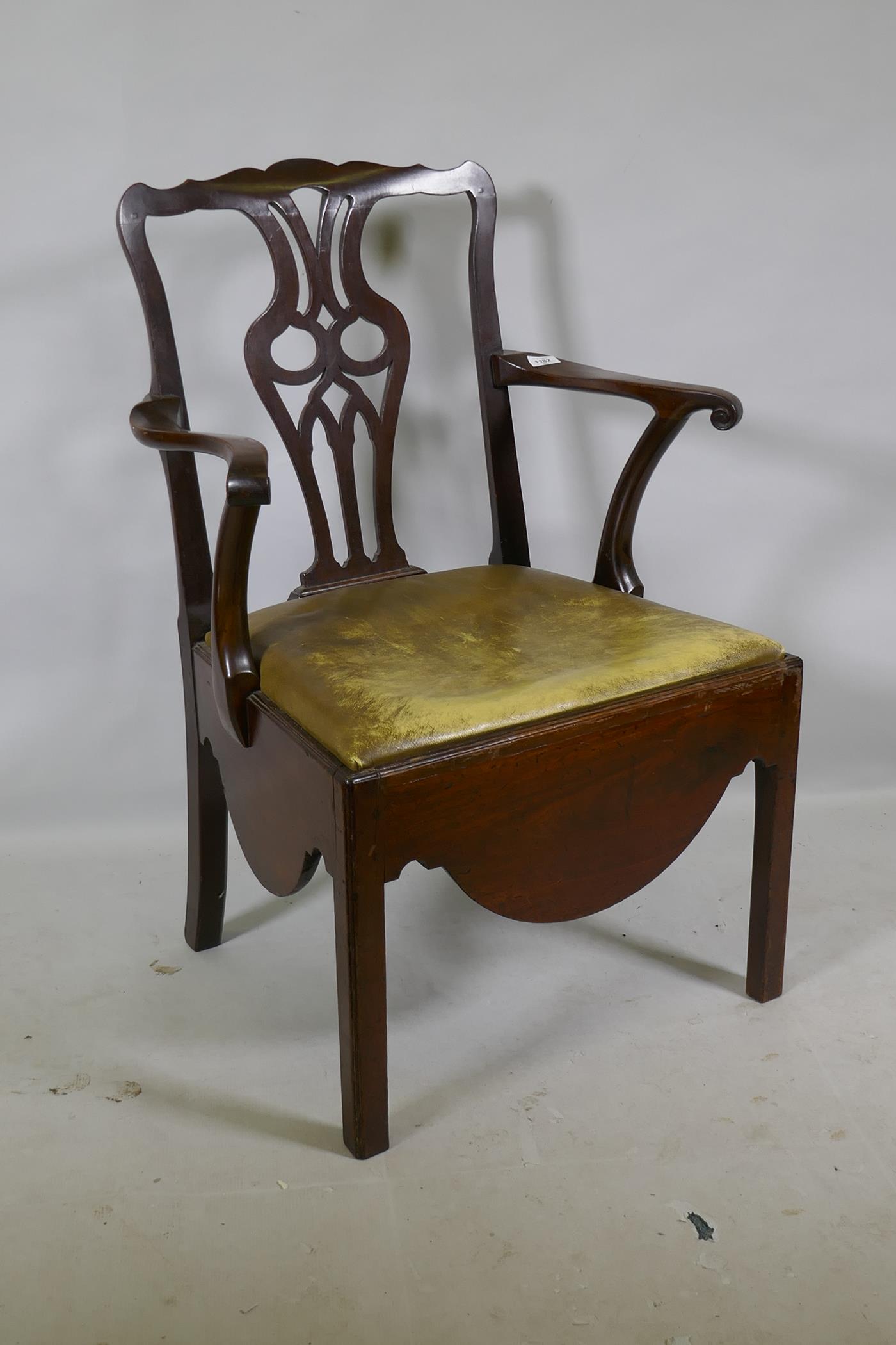 A Georgian mahogany Chippendale style elbow chair with pierced splat back, scroll arms and drop in